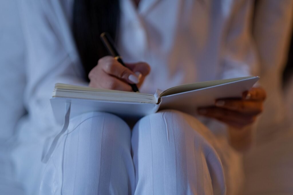Persoon bereidt een avond uit voor met telefoon en notitieboek aan tafel