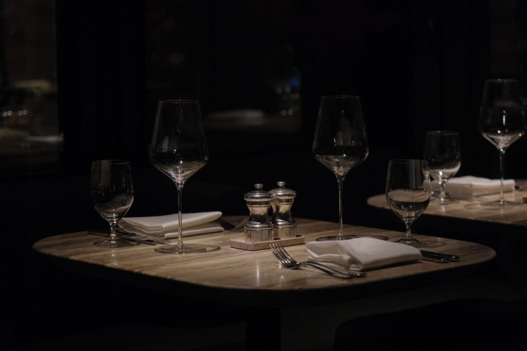 Intiem gedekte tafel voor twee met wijnglazen in warm licht