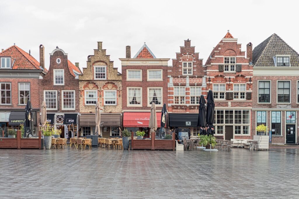 Schilderachtige Europese straat met traditionele Nederlandse gevelgebouwen en openluchtcafés.