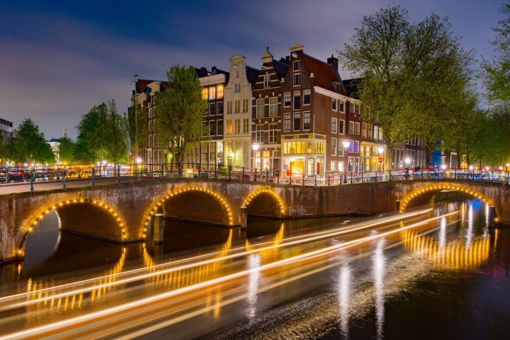 Indrukwekkende lange belichting van het verlichte Amsterdamse kanaal en historische gebouwen 's nachts.
