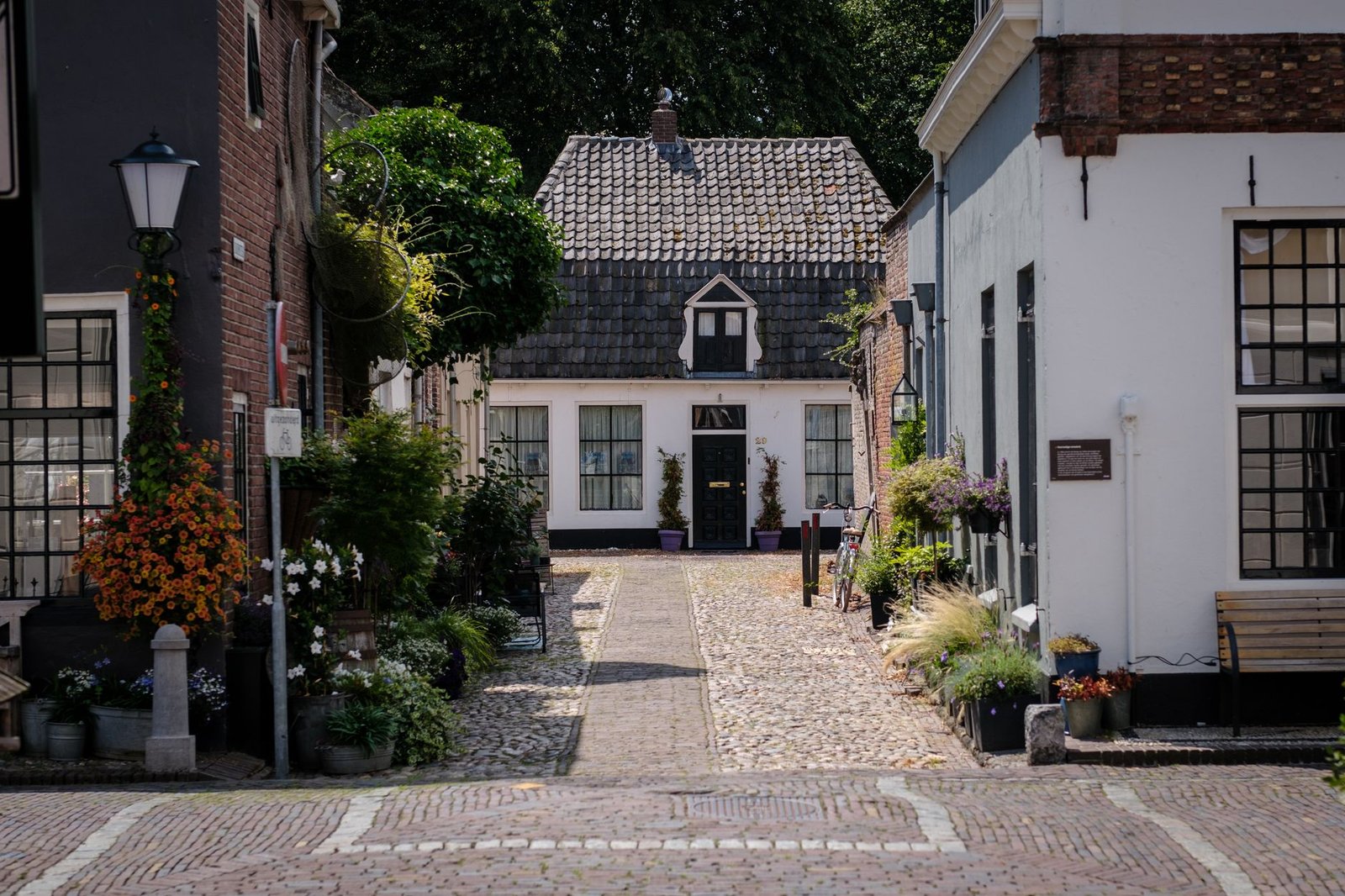 Rustige straat in Brummen, Gelderland, met bakstenen huizen en een kerktoren in de verte