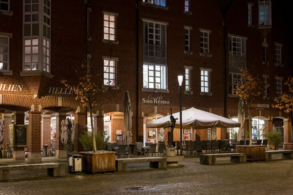 Betoverend nachtzicht van een gezellig Europees café met warme verlichting en een herfstige sfeer.