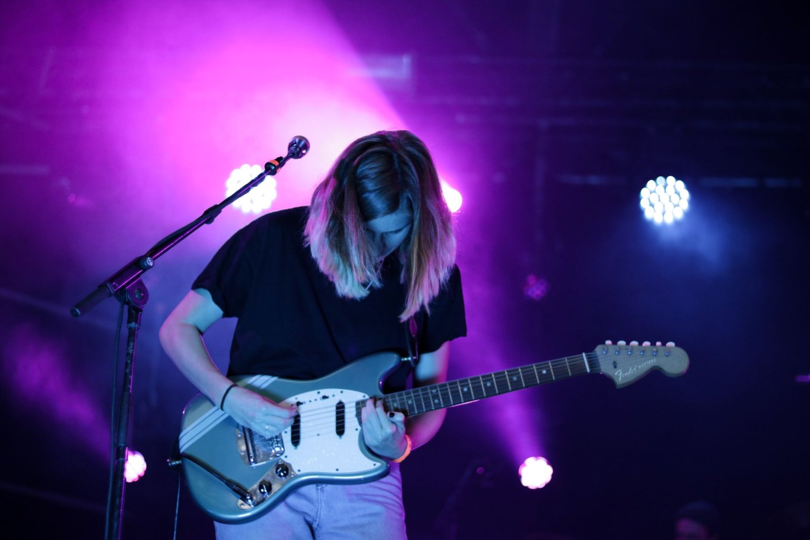 Een boeiende gitarist optredend in levendige verlichting tijdens een liveconcert in Breda, Nederland.