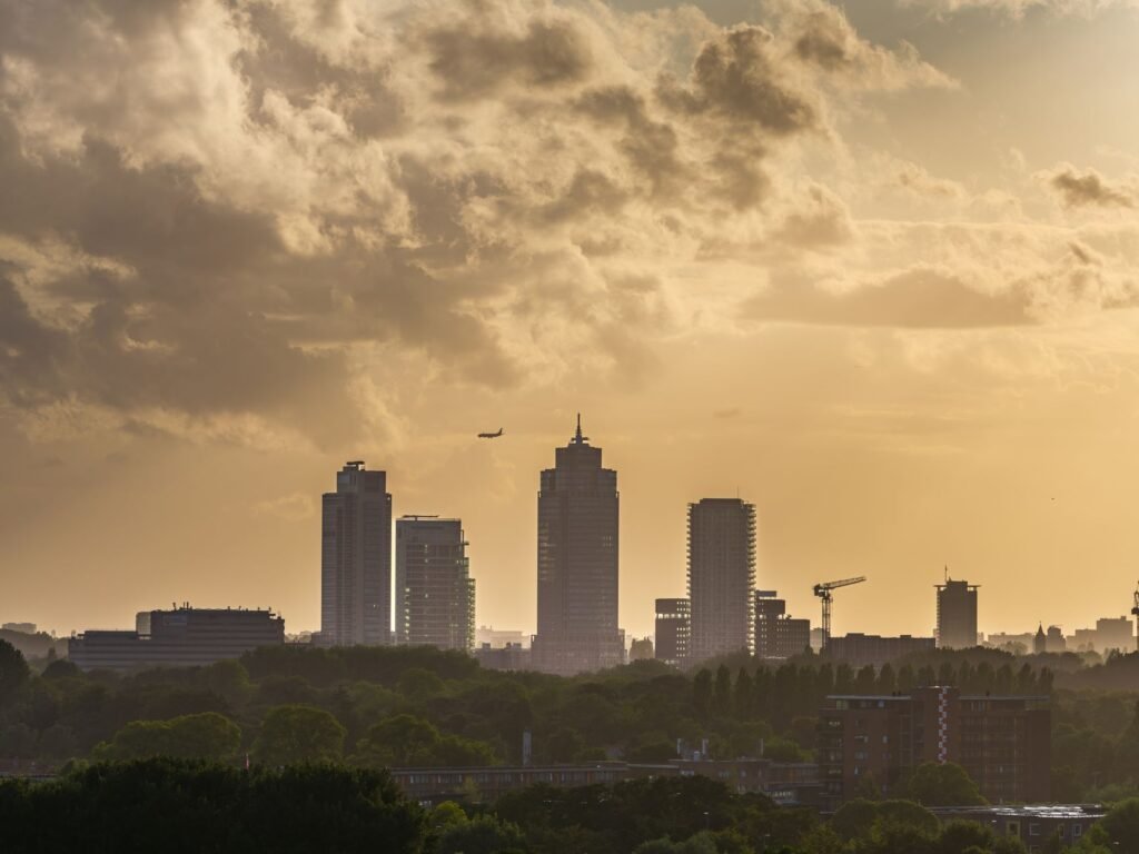 Adembenemend uitzicht tijdens het gouden uur op de skyline van de Amsterdamse Zuidas met dramatische wolken.