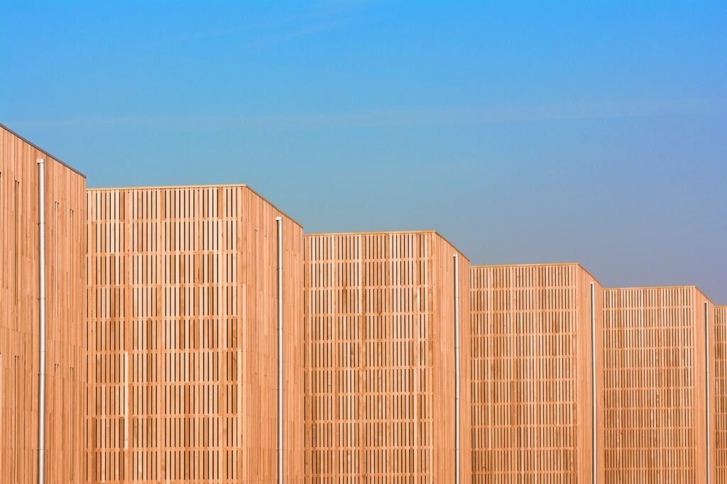 Architectonisch detail van moderne houten gevels met een blauwe lucht als achtergrond, die unieke ontwerpen en patronen laat
