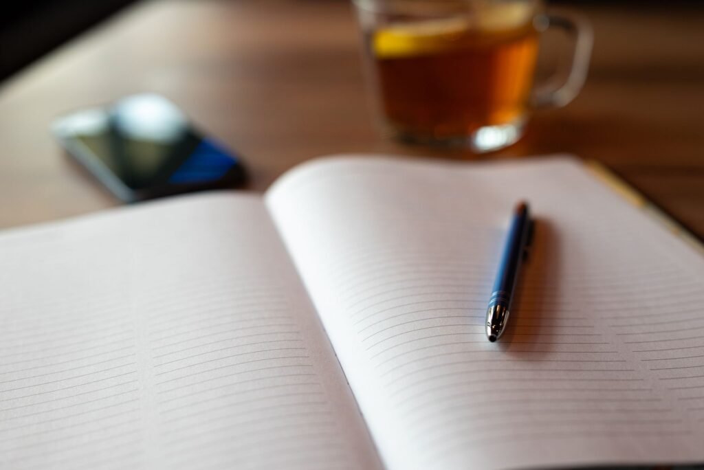 Smartphone met een directorylijst op een houten tafel naast koffie en notitieboek