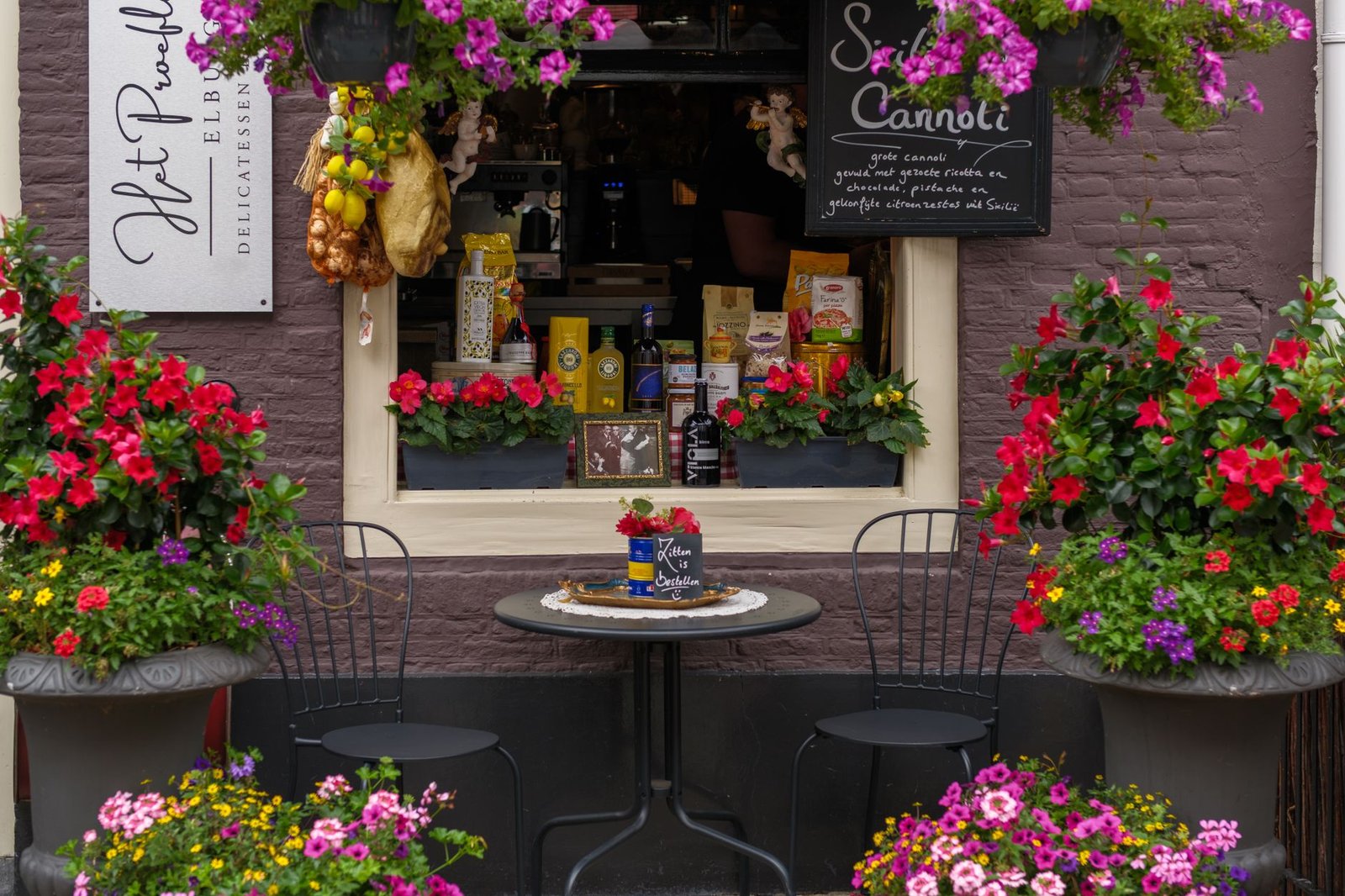 Gezellig caféterras met kleurrijke bloemen en gastronomische lekkernijen in Elburg.