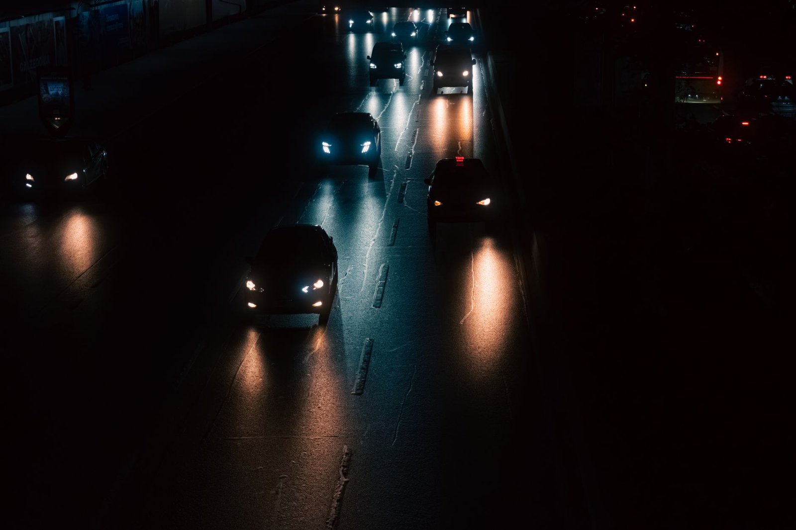 Sfeervolle foto van auto's die 's nachts door een straat in Istanbul rijden, met opvallende koplampen.