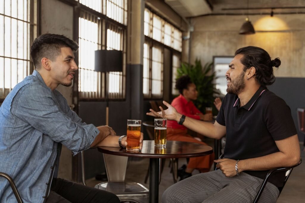 Twee volwassenen in gesprek aan een tafel in een café, passend bij communicatie en respect in Súdwest-Fryslân