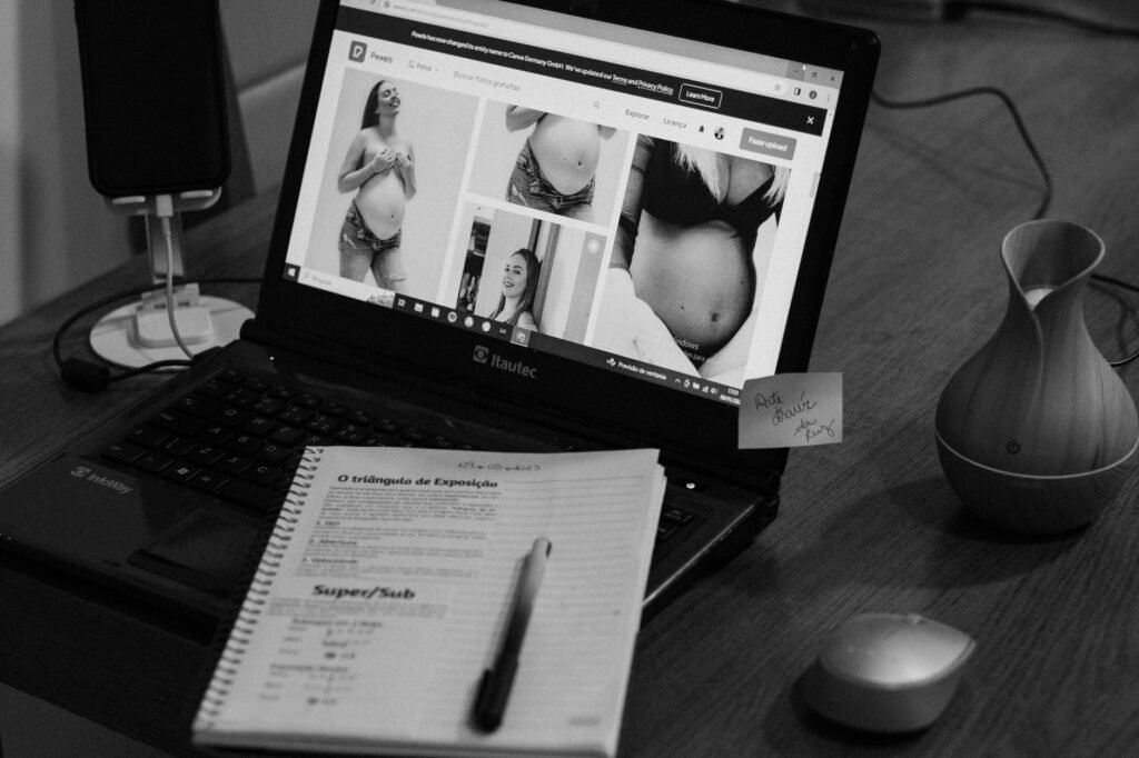 Laptop en notitieboek op een houten tafel met uitzicht op een Nederlandse kuststreek